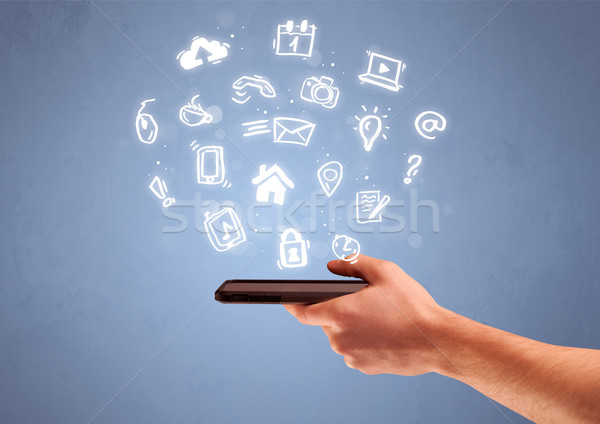 Hand holding tablet phone with drawn icons Stock photo © ra2studio