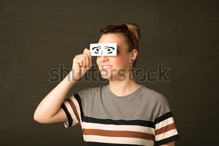 Stock photo: Cool youngster looking with a paper hand drawn eyes