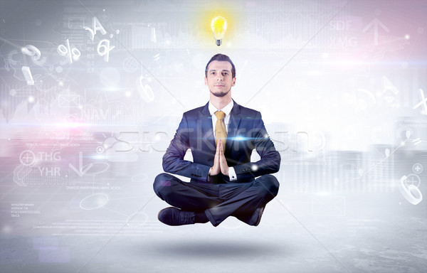 Businessman meditates with enlightenment concept Stock photo © ra2studio