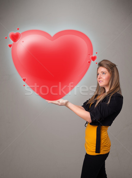 Young lady holding lovely 3d red heart Stock photo © ra2studio