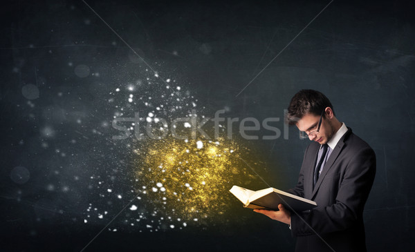 Młodych facet czytania magiczny książki tablicy Zdjęcia stock © ra2studio