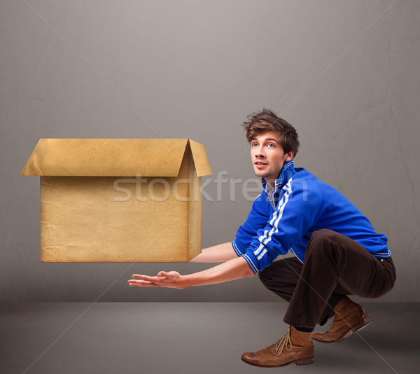 Goog-looking man holding an empty brown cardboard box Stock photo © ra2studio