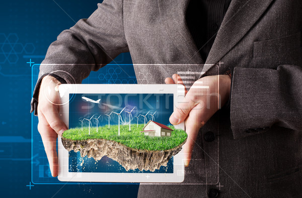 Young businessman presenting a perfect ecology land with a house and windmills Stock photo © ra2studio