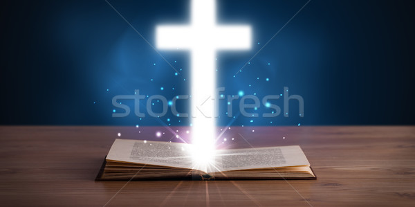 Stock photo: Open holy bible with glowing cross in the middle