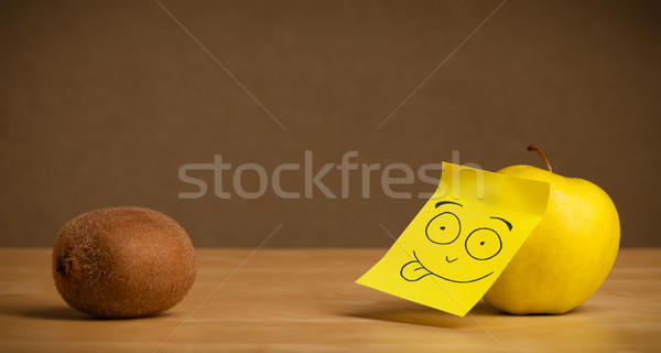 Apple with post-it note sticking out tongue to kiwi Stock photo © ra2studio