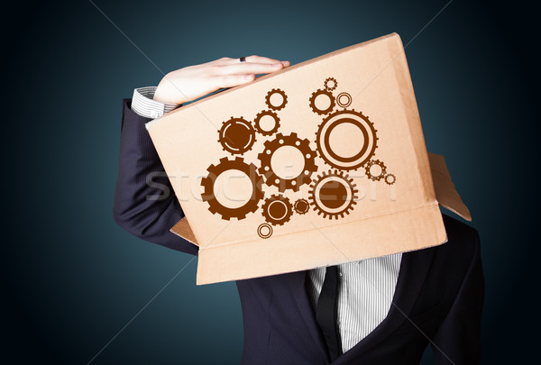 Businessman gesturing with a cardboard box on his head with spur Stock photo © ra2studio