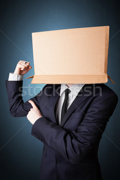 Businessman gesturing with a cardboard box on his head Stock photo © ra2studio