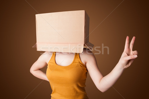 Young girl gesturing with a cardboard box on his head Stock photo © ra2studio