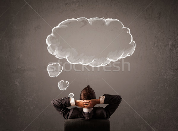 Businessman sitting with cloud thought above his head Stock photo © ra2studio