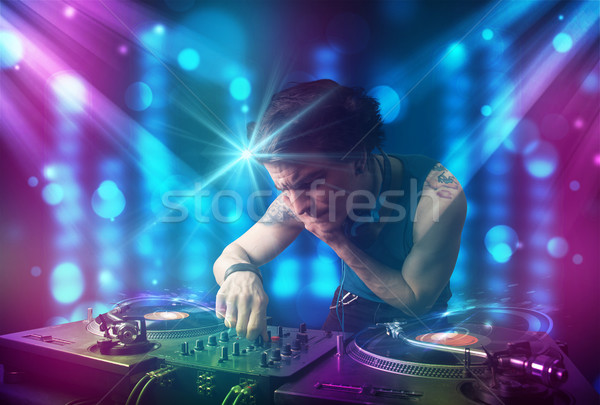 Dj mixing music in a club with blue and purple lights Stock photo © ra2studio