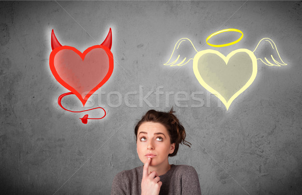 Woman standing between the angel and devil hearts Stock photo © ra2studio
