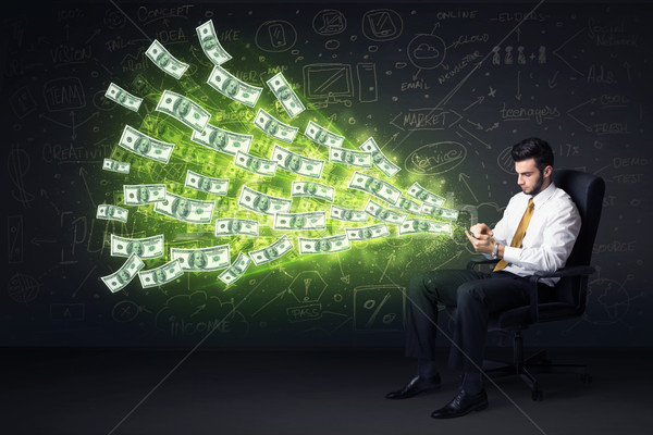 Businessman sitting in chair holding tablet with dollar bills co Stock photo © ra2studio