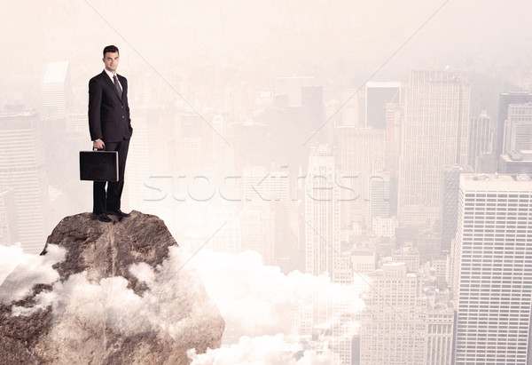 Happy businessman standing on stone top Stock photo © ra2studio