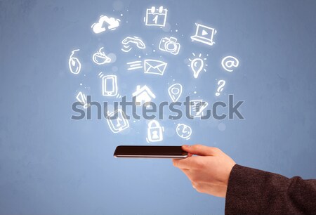 Hand holding tablet phone with drawn icons Stock photo © ra2studio