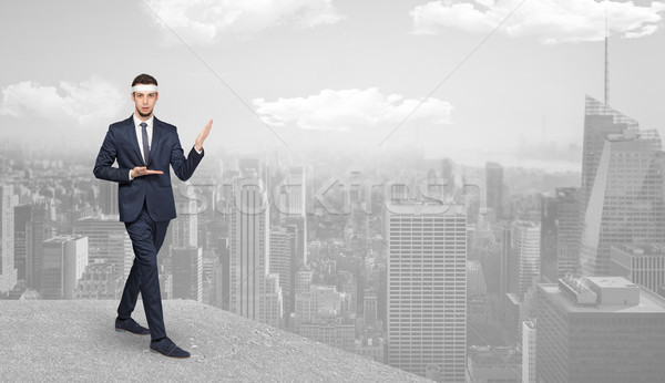 Stock photo: Suited karate man doing karate tricks on the top of a metropolitan city
