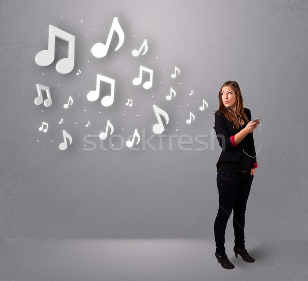 Pretty young woman singing and listening to music with musical notes Stock photo © ra2studio