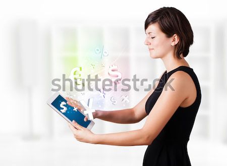 Stock photo: Young woman looking at modern tablet with currency icons