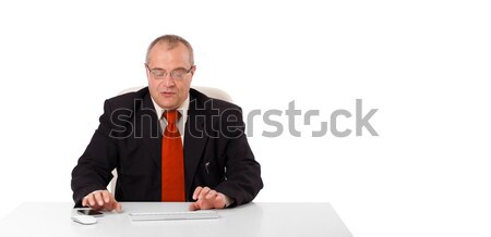 businessman sitting at desk and typing on keyboard with copy scape, isolated on white Stock photo © ra2studio