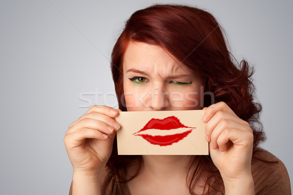 Stock photo: Happy pretty woman holding card with kiss lipstick mark