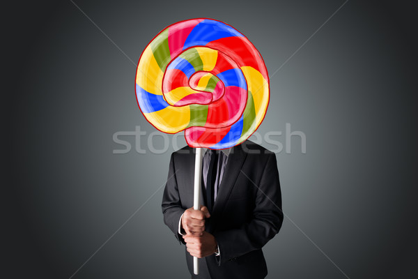 Businessman holding a lollipop Stock photo © ra2studio