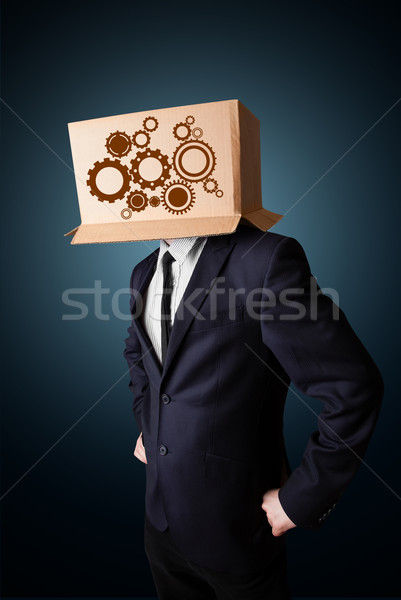 Businessman gesturing with a cardboard box on his head with spur Stock photo © ra2studio