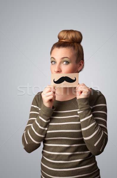 Happy cute girl holding paper with mustache drawing  Stock photo © ra2studio