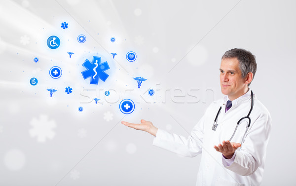 Doctor with blue medical icons Stock photo © ra2studio