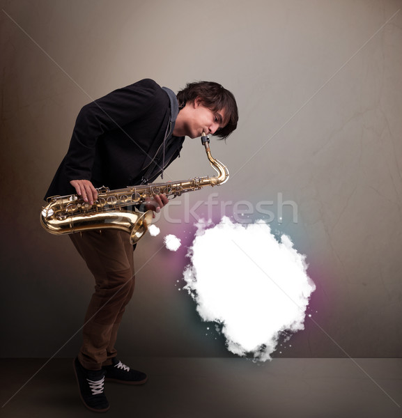 Young man playing on saxophone with copy space in white cloud Stock photo © ra2studio