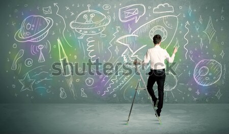 Young businessman drawing rocket Stock photo © ra2studio