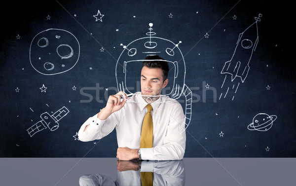 Sales person drawing helmet and space rocket Stock photo © ra2studio