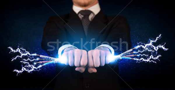 Business person holding electrical powered wires Stock photo © ra2studio