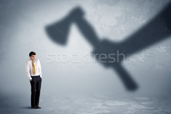 Stock photo: Businessman afraid of a huge shadow hand holding an axe concept