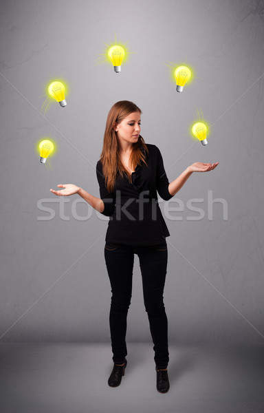 young lady standing and juggling with light bulbs Stock photo © ra2studio