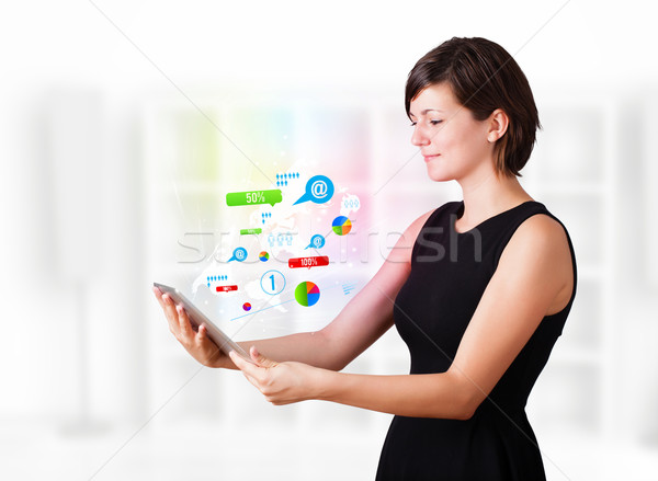 Young business woman looking at modern tablet with colourful technology icons Stock photo © ra2studio