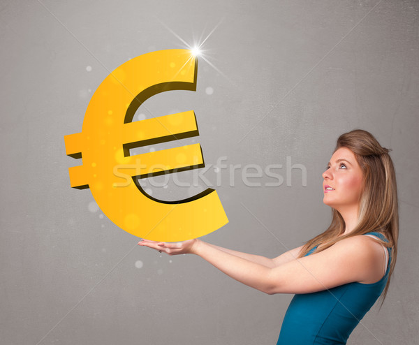 Beautiful girl holding a big 3d gold euro sign Stock photo © ra2studio