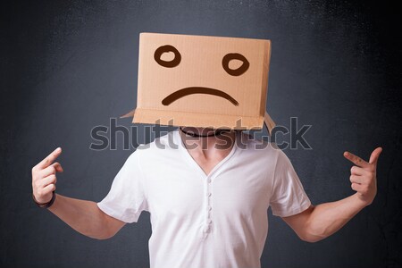 Stock photo: Young man with a brown cardboard box on his head with sad face