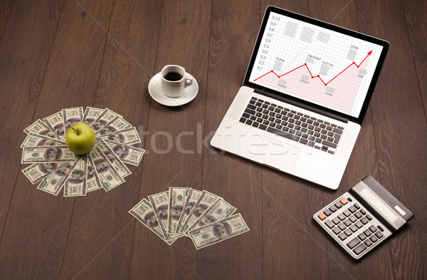 Computer desk with laptop and red arrow chart in screen Stock photo © ra2studio