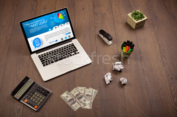 Laptop on office desk with business website on screen Stock photo © ra2studio