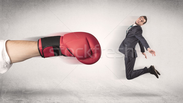 Businessman gets fired by a huge boxing hand Stock photo © ra2studio