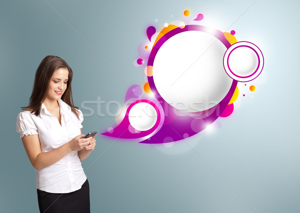 Pretty young woman holding a phone and presenting abstract speech bubble copy space Stock photo © ra2studio