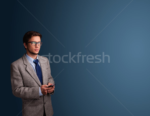 Young man standing and typing on her phone with copy space Stock photo © ra2studio