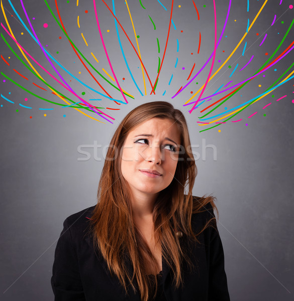 Young girl thinking with colorful abstract lines overhead Stock photo © ra2studio