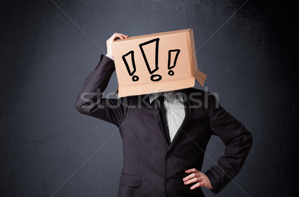Businessman gesturing with a cardboard box on his head with excl Stock photo © ra2studio