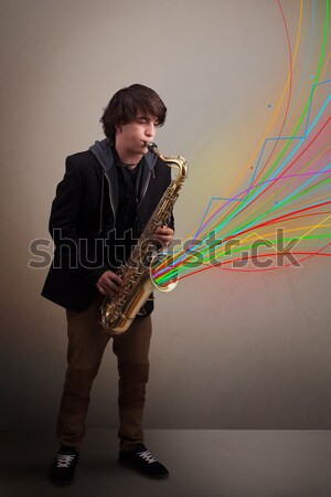 Attractive musician playing on saxophone while colorful abstract Stock photo © ra2studio