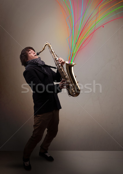Attractive musician playing on saxophone while colorful abstract Stock photo © ra2studio