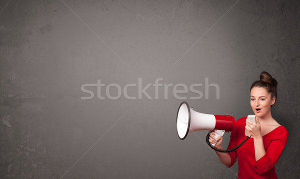 Girl shouting into megaphone on copy space background Stock photo © ra2studio