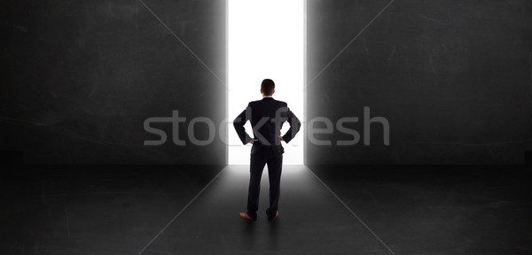 Uomo d'affari guardando muro luce tunnel apertura Foto d'archivio © ra2studio