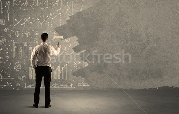 Salesman painting over charts on wall Stock photo © ra2studio