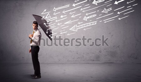 Business man standing with umbrella and drawn arrows hitting him Stock photo © ra2studio