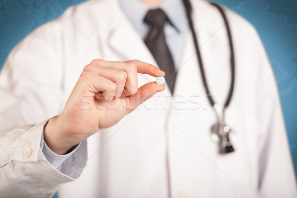 Doctor in white holding a pill Stock photo © ra2studio